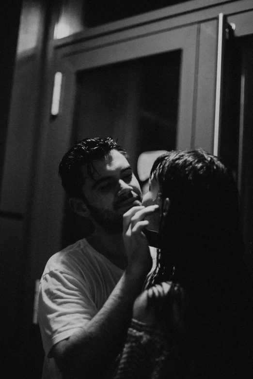 a man is helping a woman brush her teeth