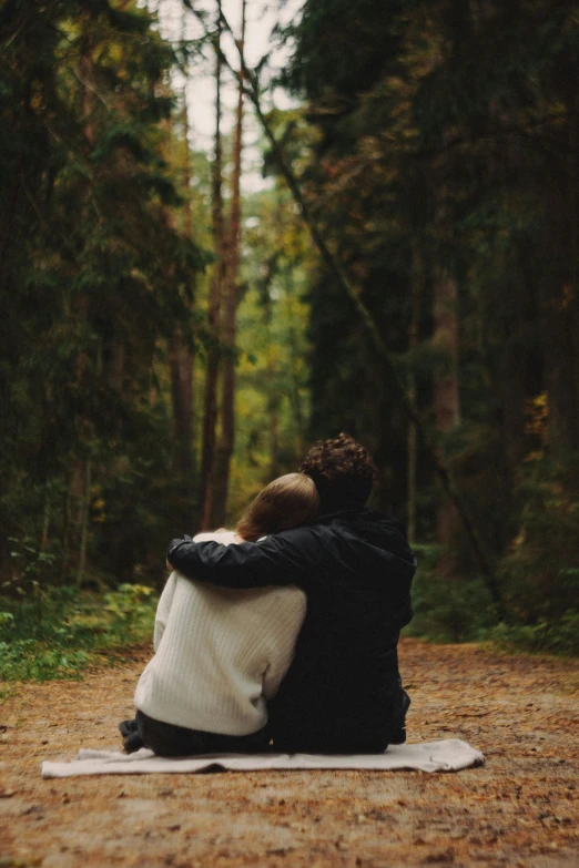 a couple sits together on the ground while emcing