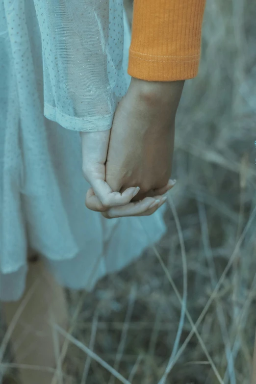 two people holding hands in their dress are standing in a field