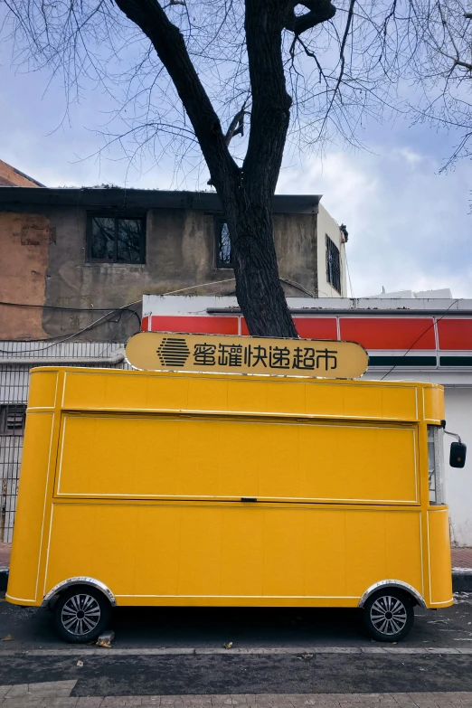 a large yellow food truck on the side of a road