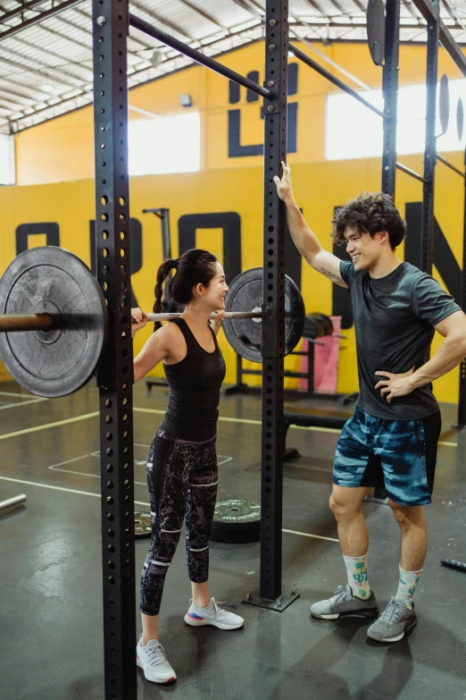 a couple does squats in a gym