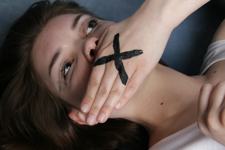 a girl with her hand tattooed to look like a cross