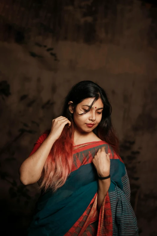 woman in saree, standing and looking to her left with closed arm