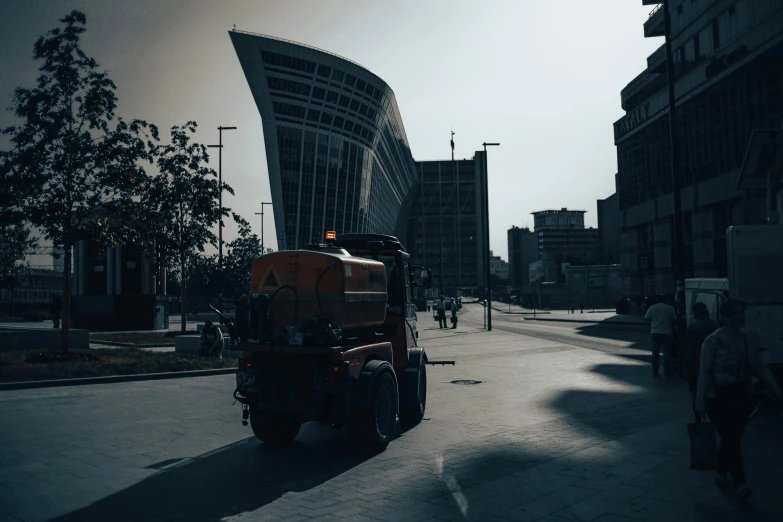 a large yellow truck sitting in the middle of a city