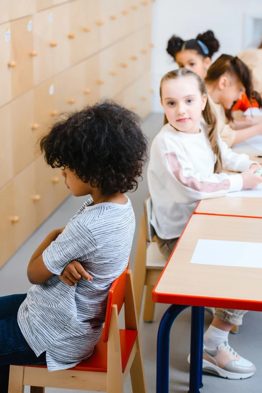 two s sitting at the desk in front of two other girls