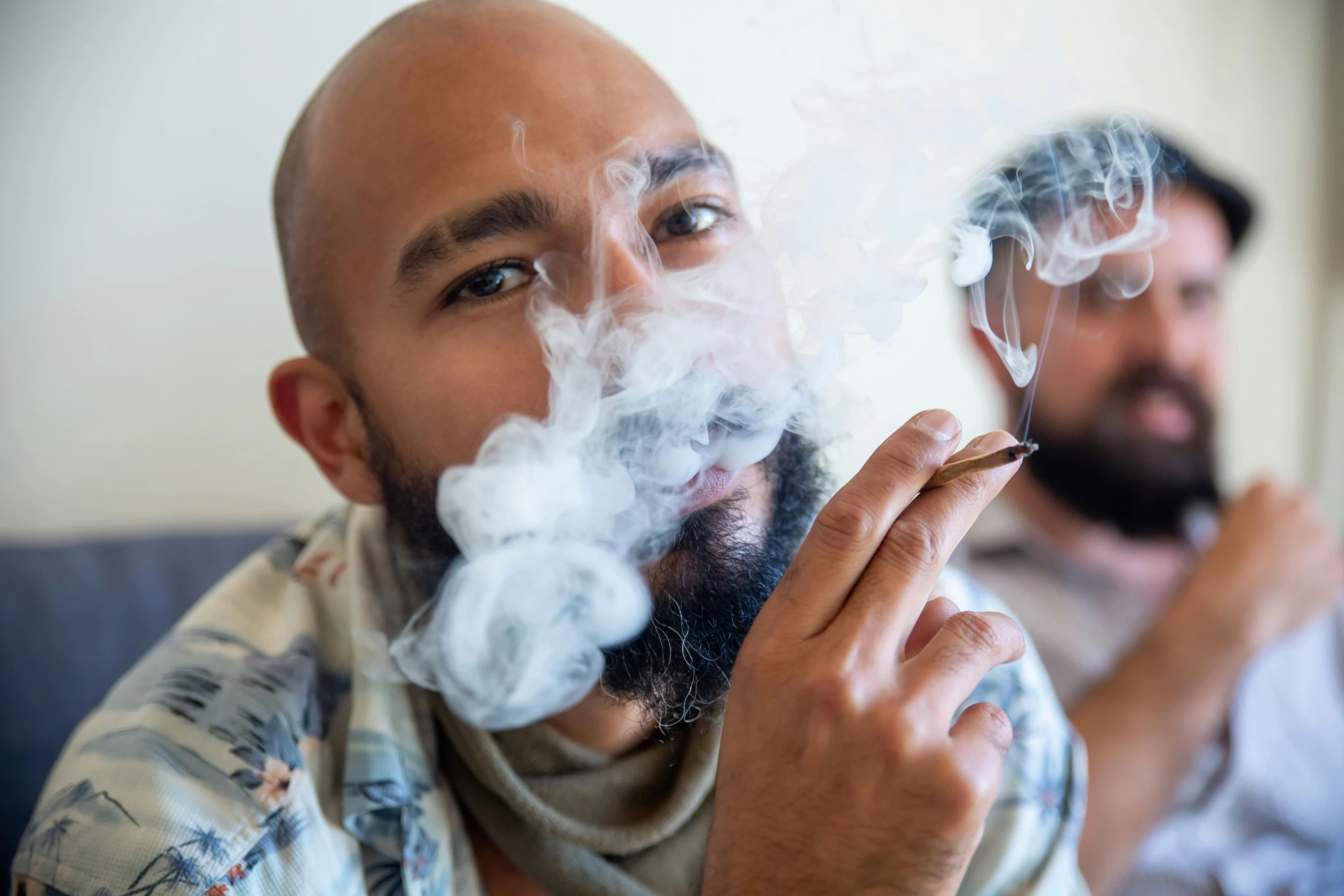 a man smoking and looking at the mirror