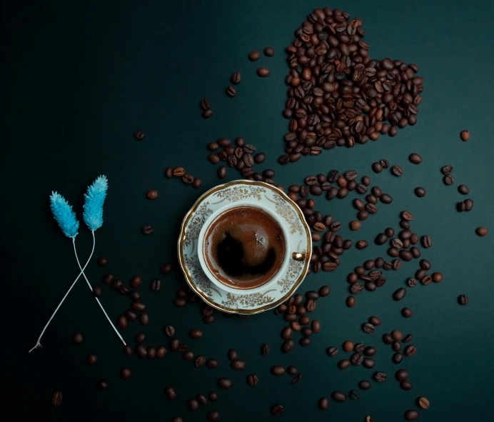 cup of coffee, coffee beans, and a pair of blue toothpicks