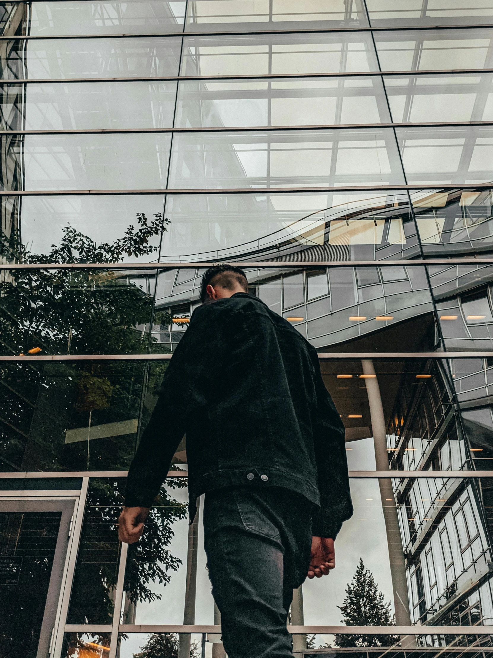 man walking against a window with reflection on it