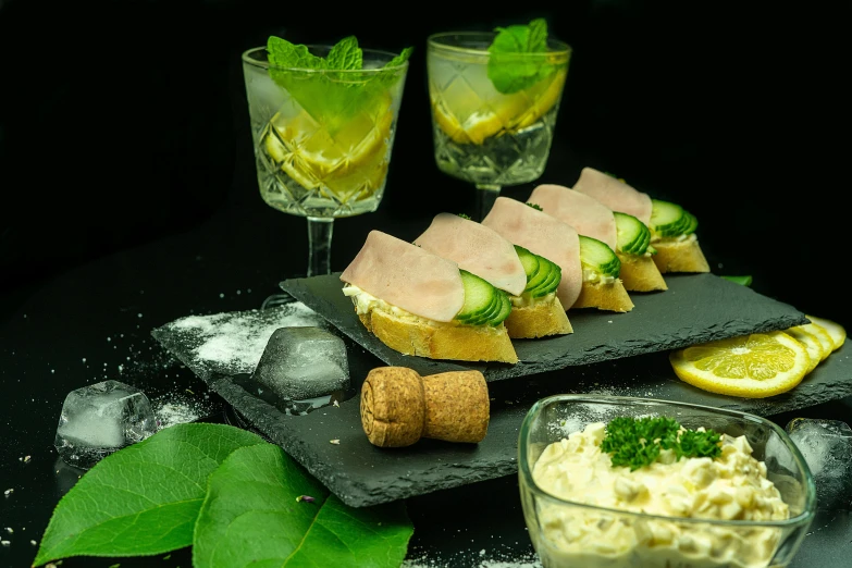 a plate topped with cucumber, cheese and ers next to drinks