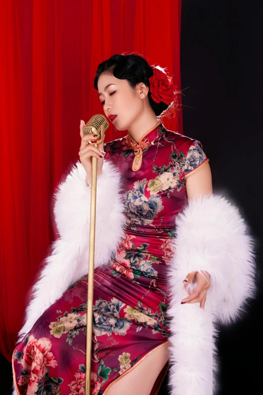 a woman sitting in front of a red curtain with an umbrella