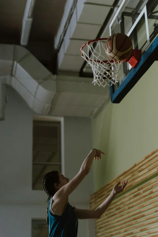 a man in a blue shirt dunking a basketball