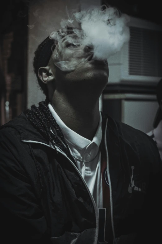 a man smoking and looking up with smoke billowing from the mouth