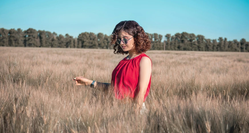 woman in a field with trees in the background