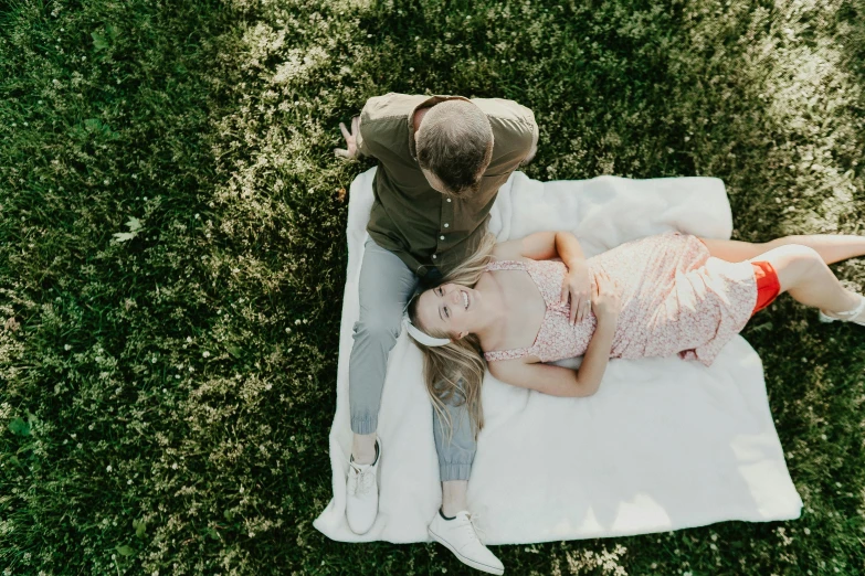 a couple lying down on a towel outside together