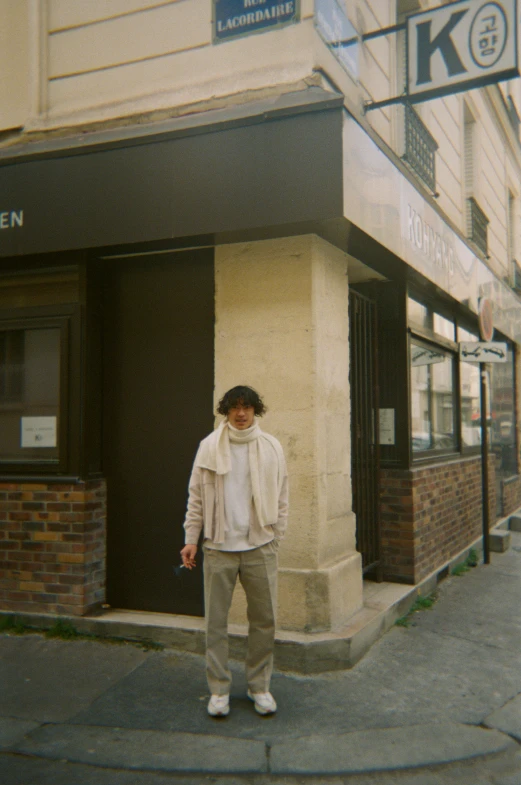 a man standing on the sidewalk outside of a building