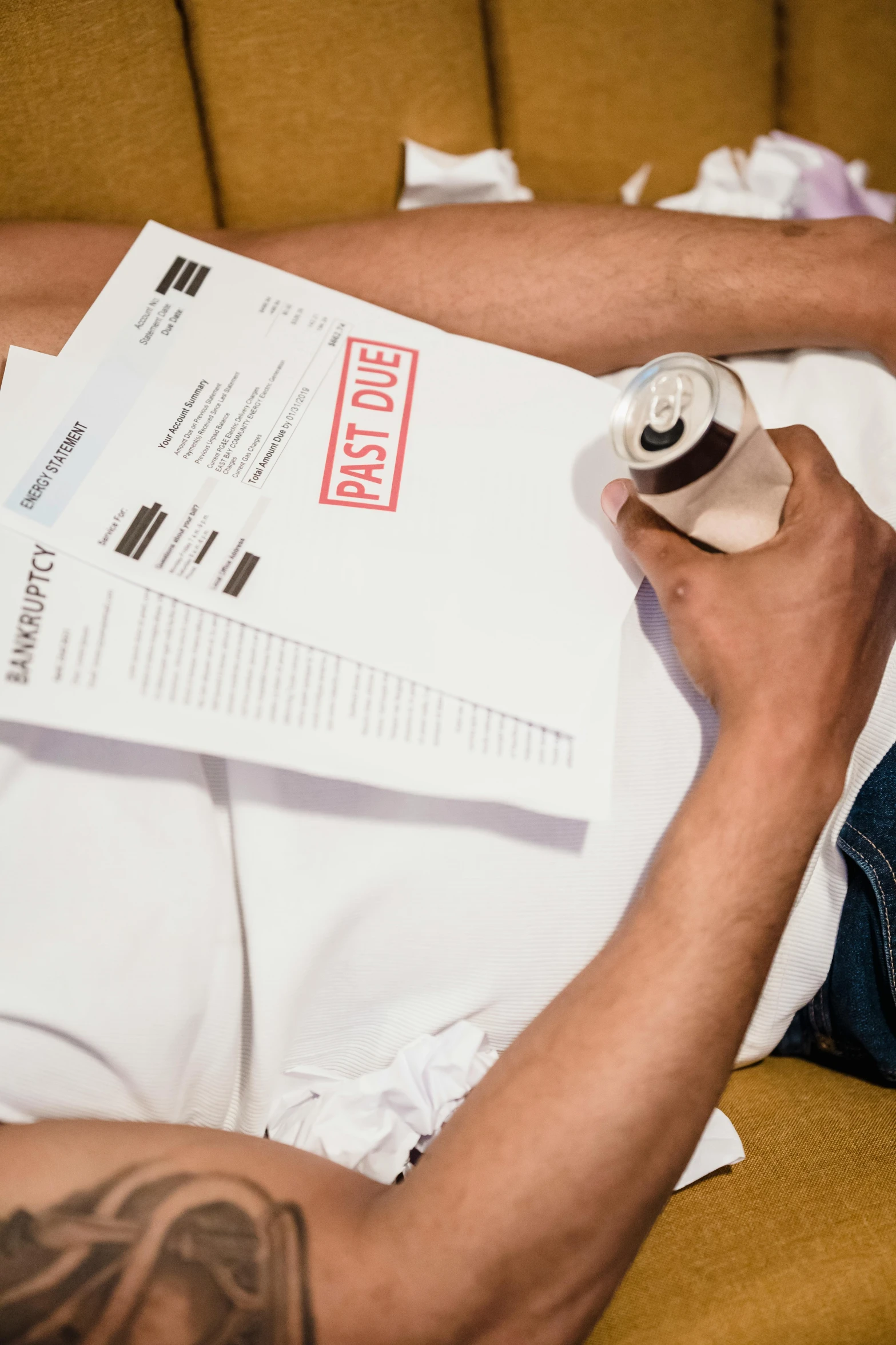 a person lying down with some paper and a bottle