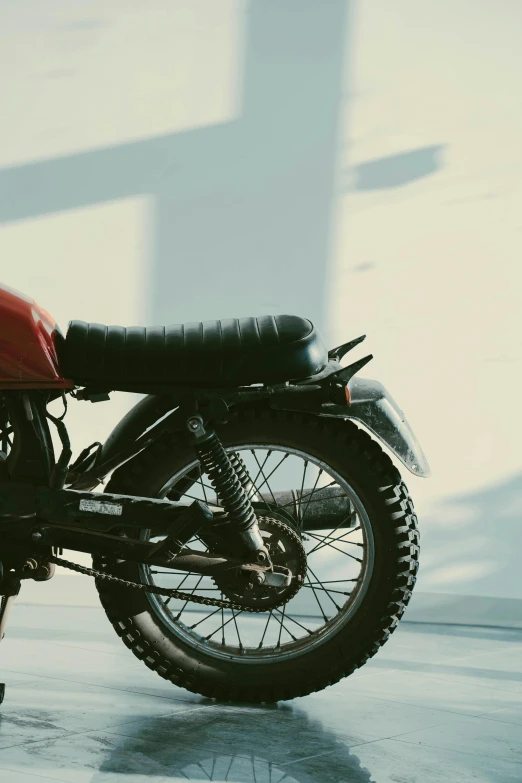 a motorcycle sits in the light and is casting a shadow