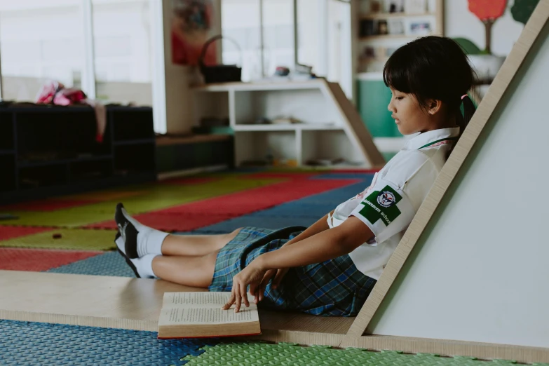 a small boy sitting on the floor reading