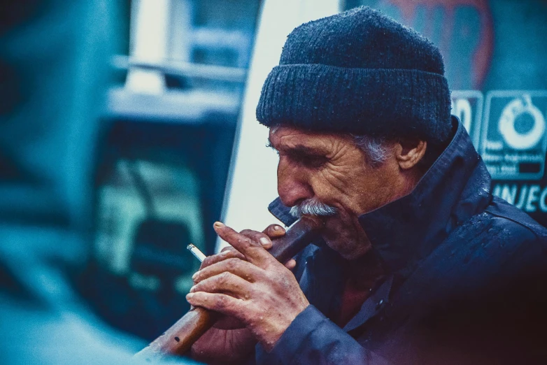 a man that is smoking a cigarette in his hand