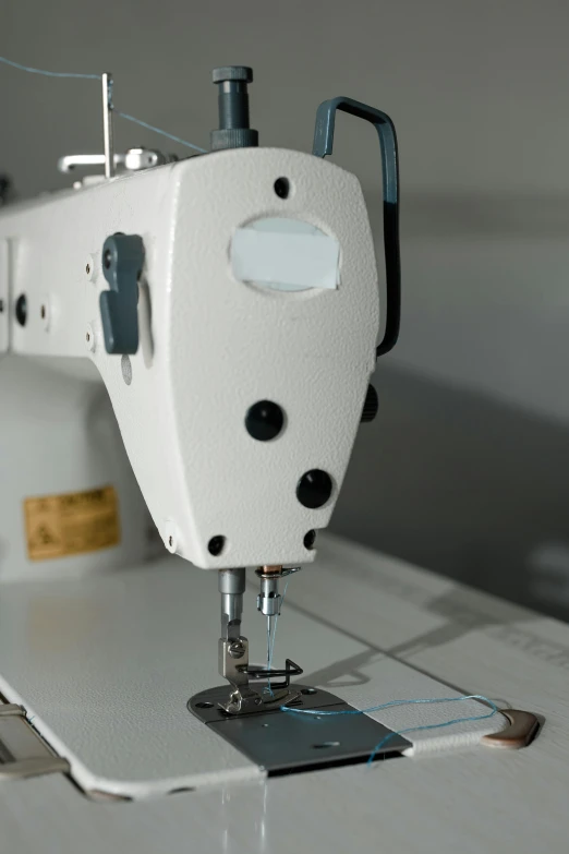 the sewing machine is using the needle to stitch a piece