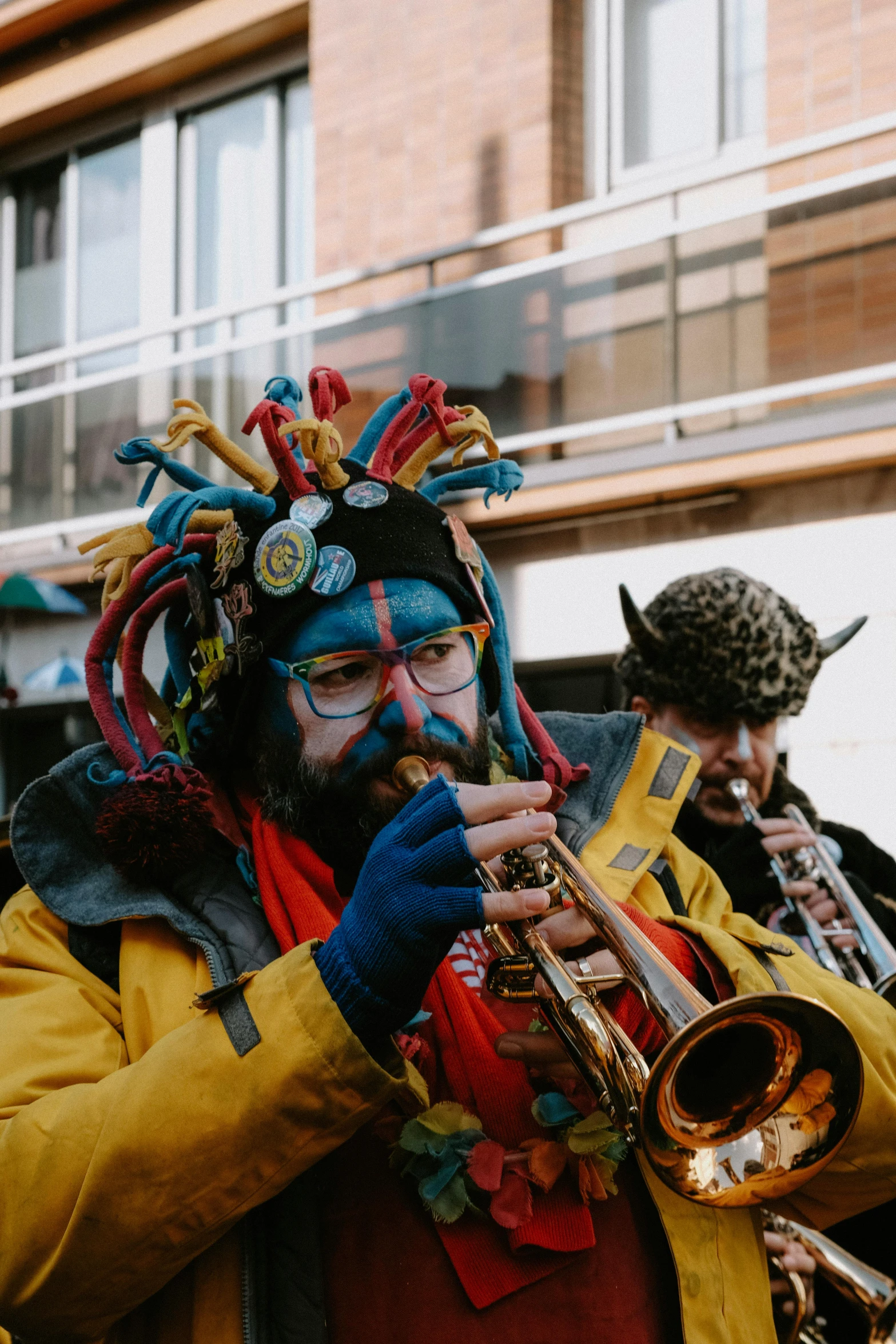 man with headdress and other music in street