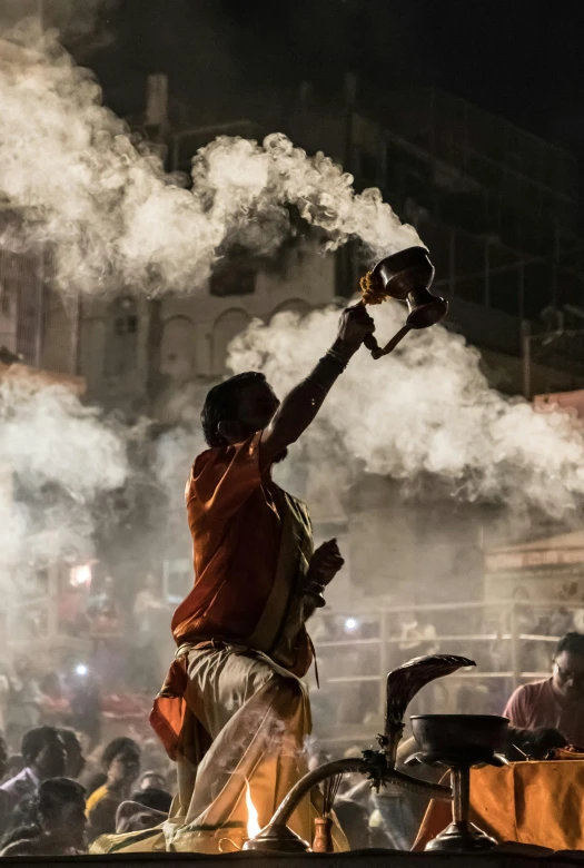 smoke coming from a bottle of beer is being thrown to a man holding onto a burning candle