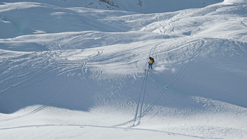 a person skis down the slope with other people looking on