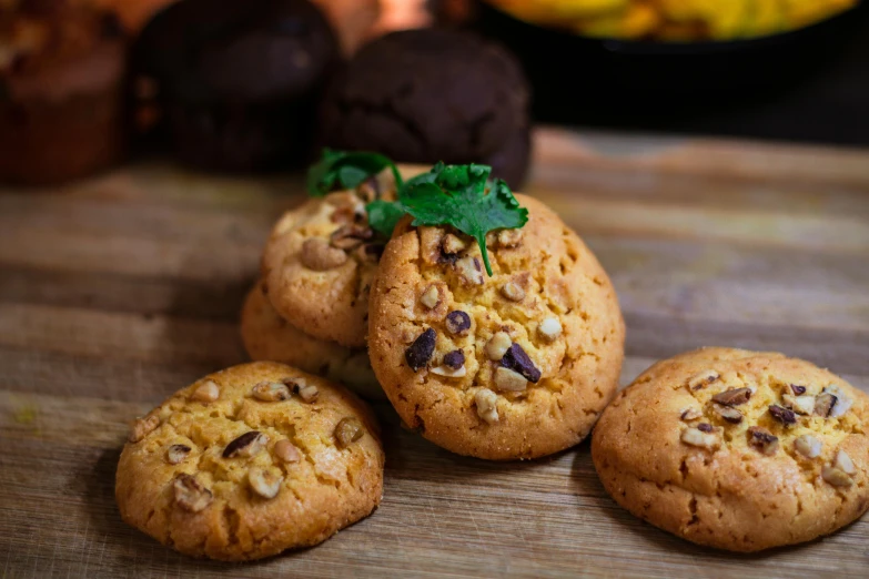 several cookies on a wooden board are next to a plant