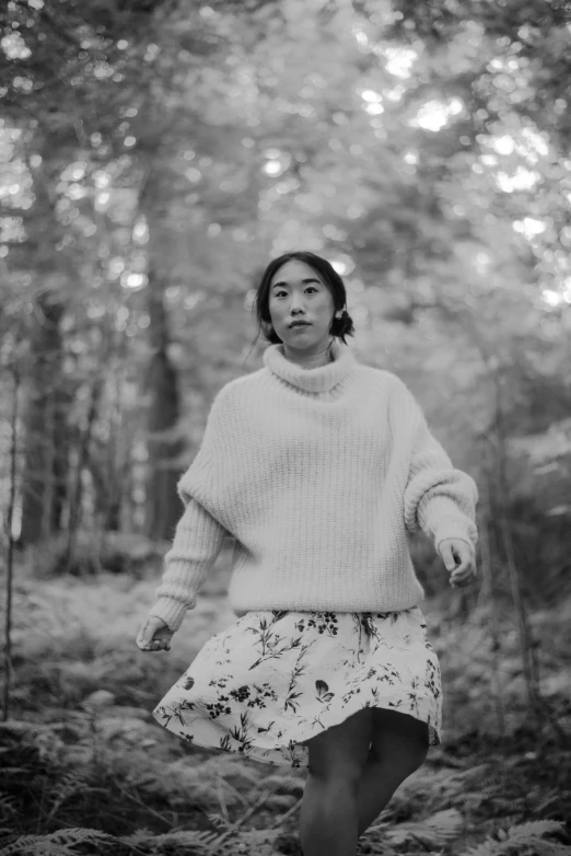 black and white pograph of a woman walking in the woods