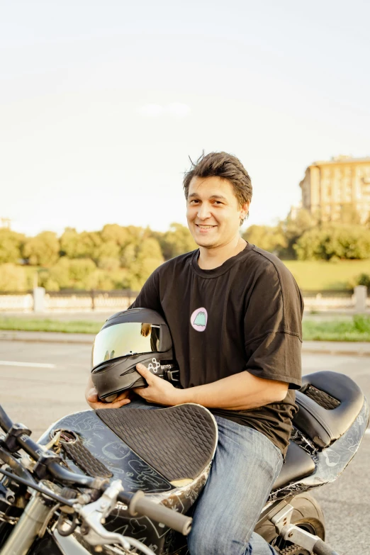 a man smiles while sitting on his motorcycle