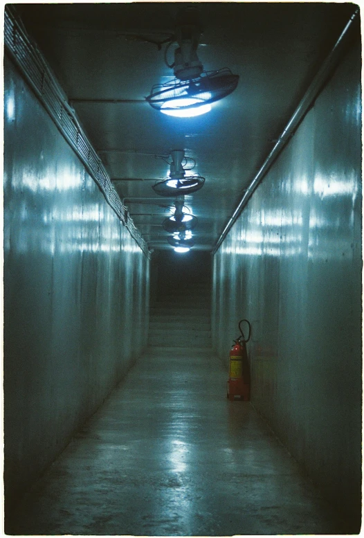 a hallway with lots of stalls, lights and an orange fire hydrant