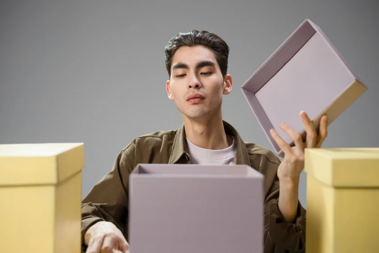 a young man holding a large square object in his hand