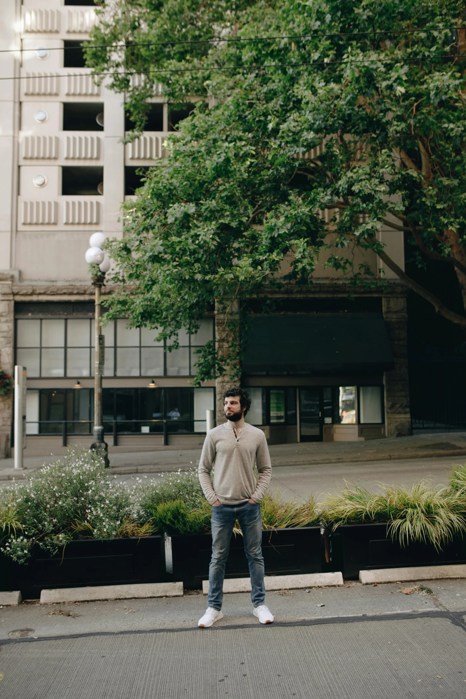 a man standing in front of a building near a lot of trees