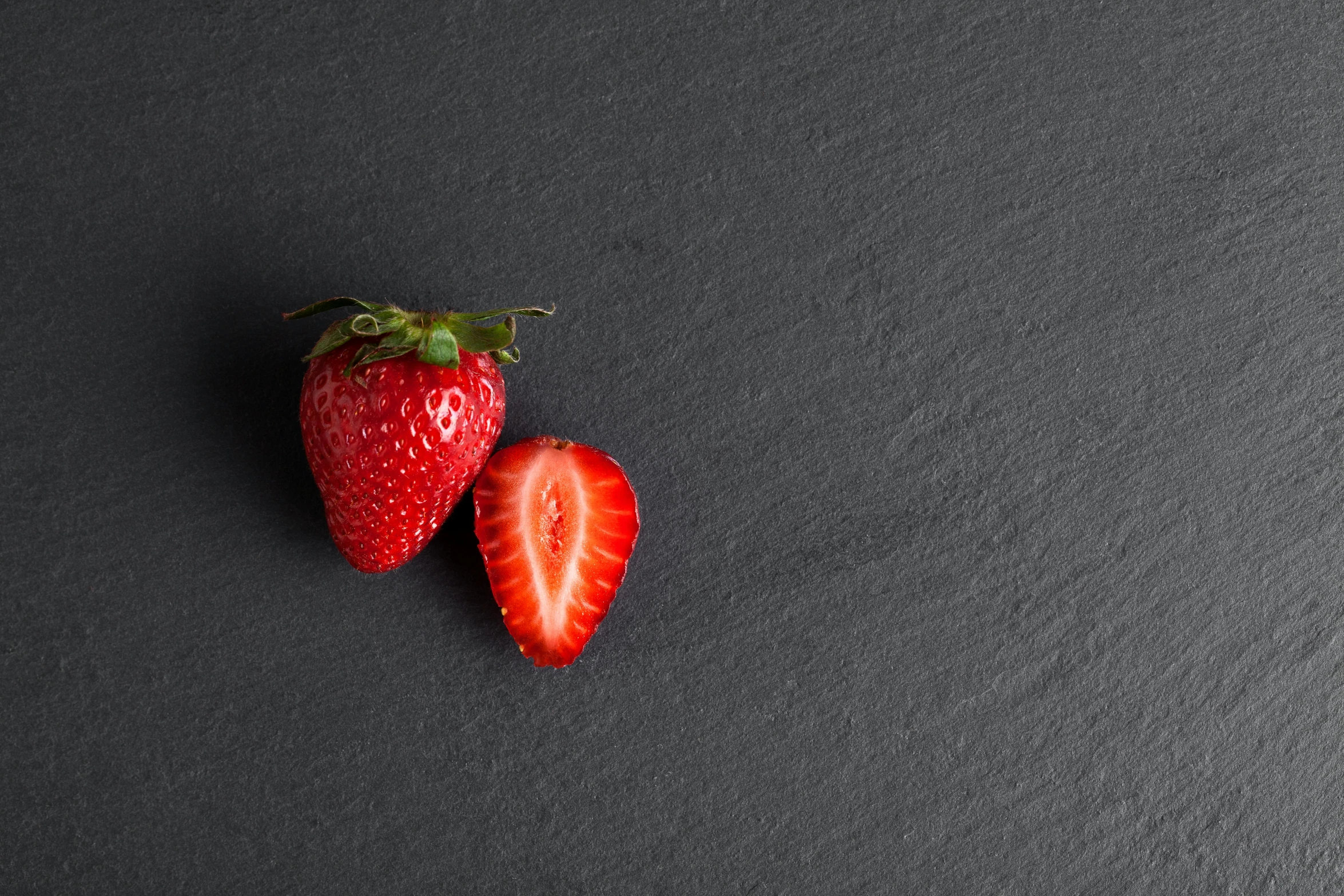 two strawberries sit on top of one another