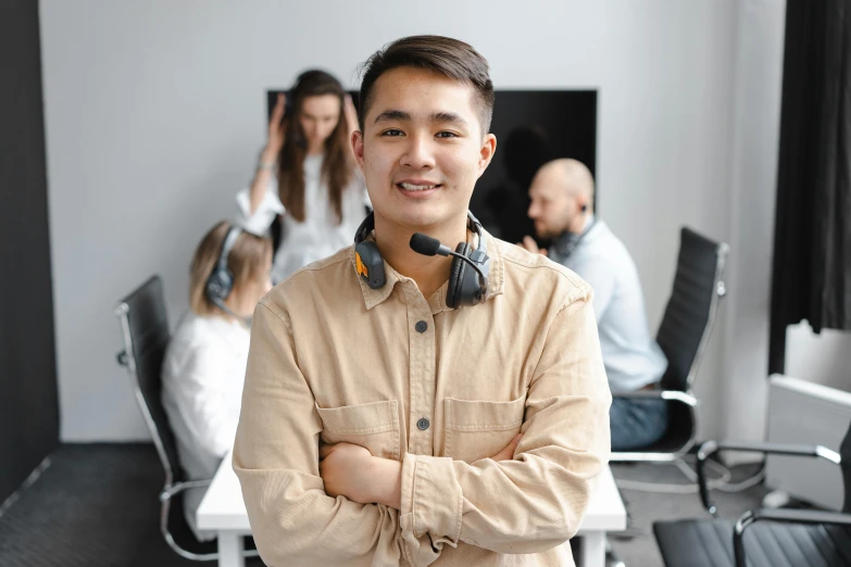 an asian guy smiling with his headset to his ear