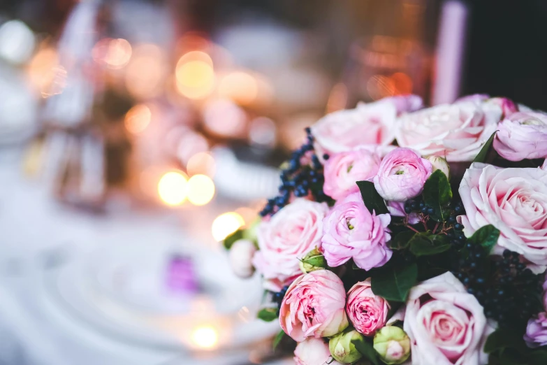 a pink bouquet of roses sitting on top of a table