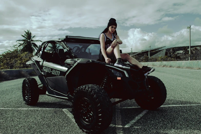 a girl sitting on top of a black off - road vehicle