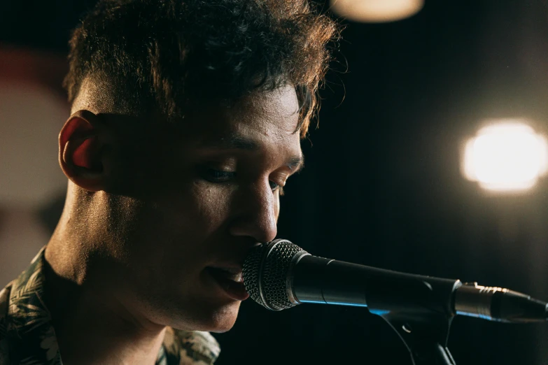 a close up of a person singing into a microphone