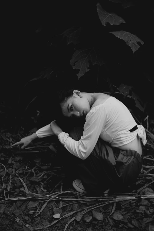 a young man sits in a dark area with his head down