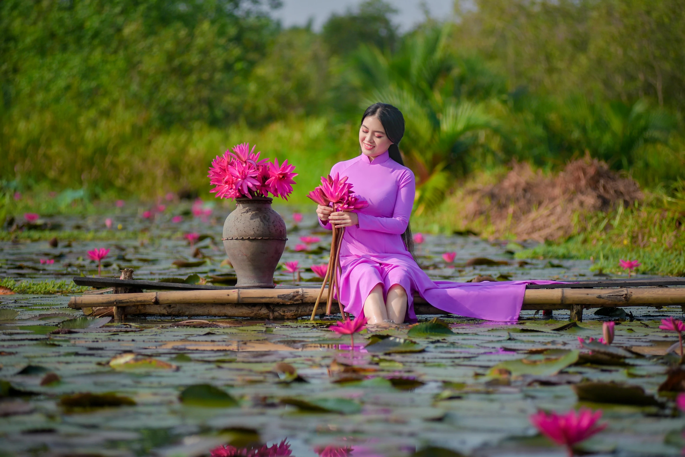 a woman in purple sitting on some logs near flowers