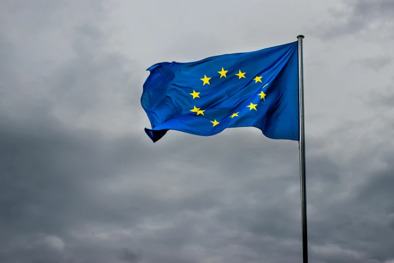 the eu flag flies high on a cloudy day