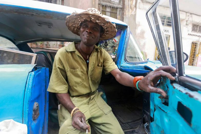 a smiling man sitting inside of an old truck