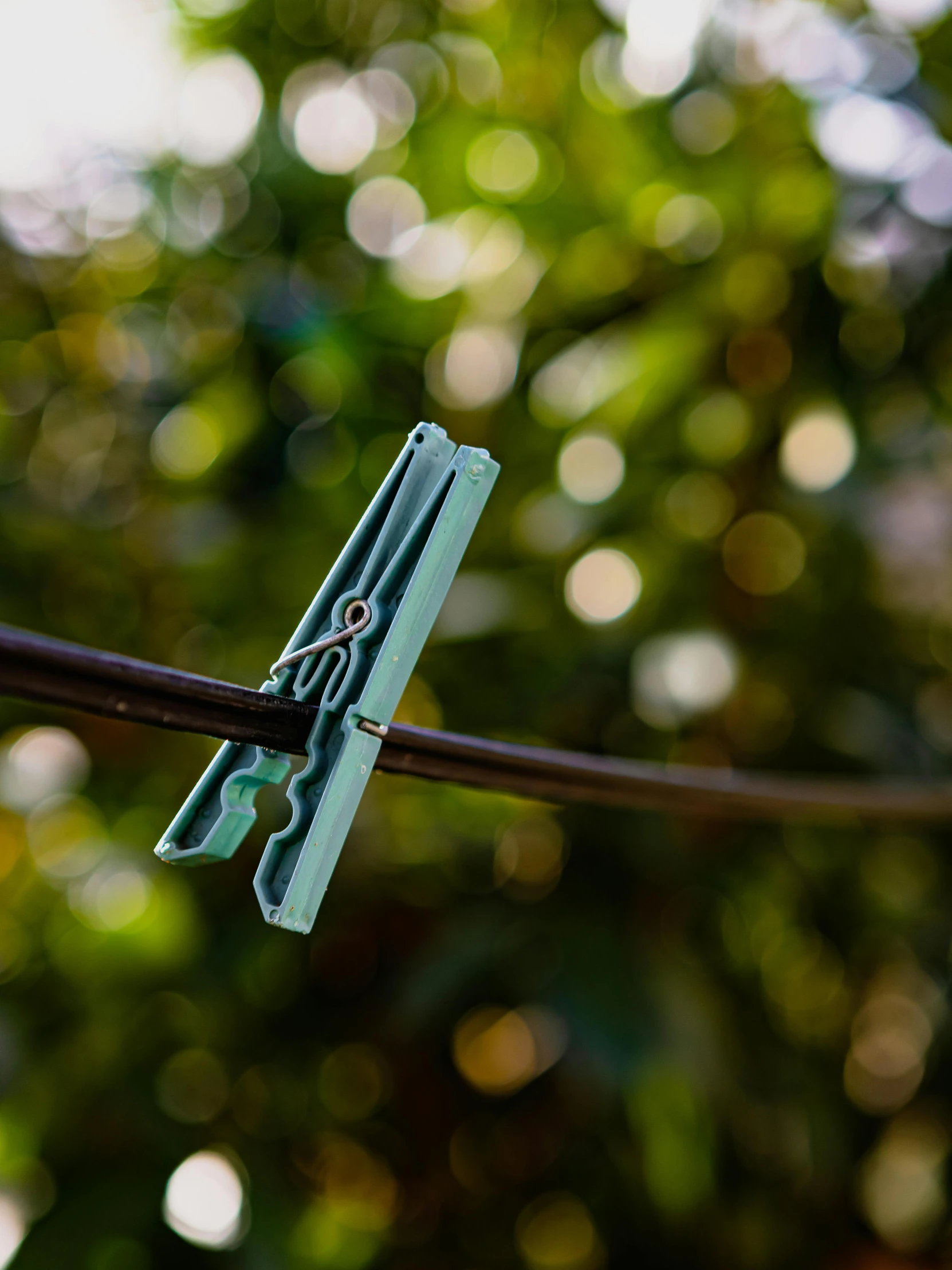 a small blue plastic tool is tied on a piece of wire