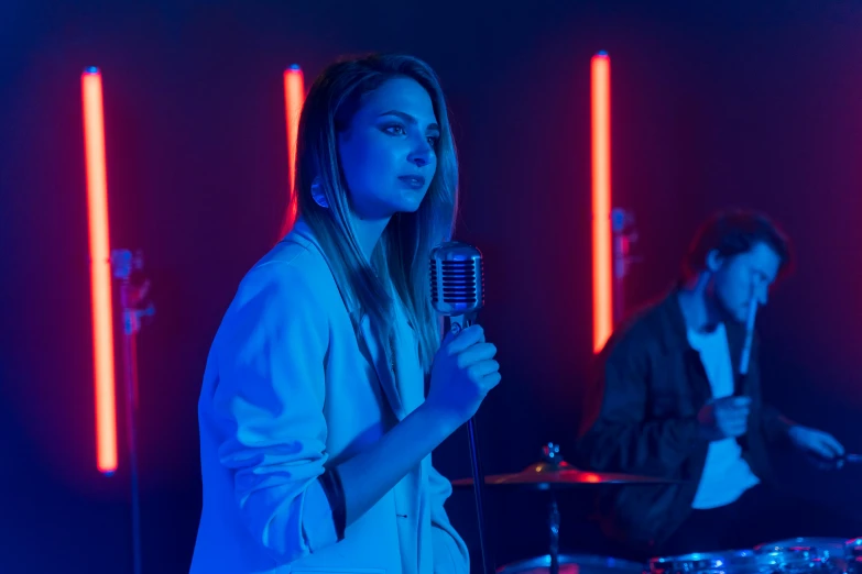 a man standing next to a woman while singing into a microphone