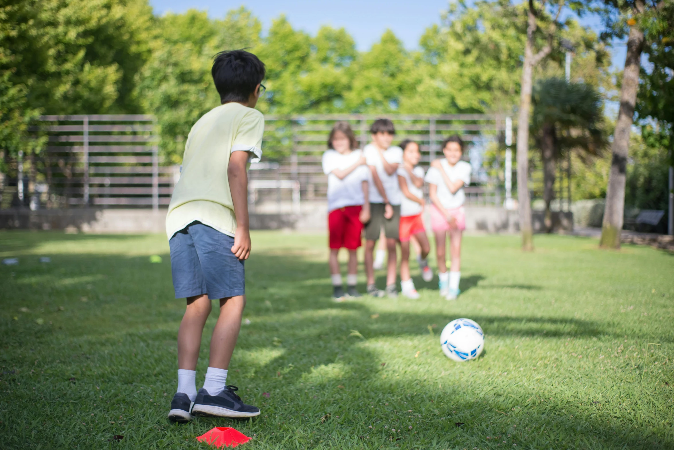 a group of s kicking a soccer ball down a field