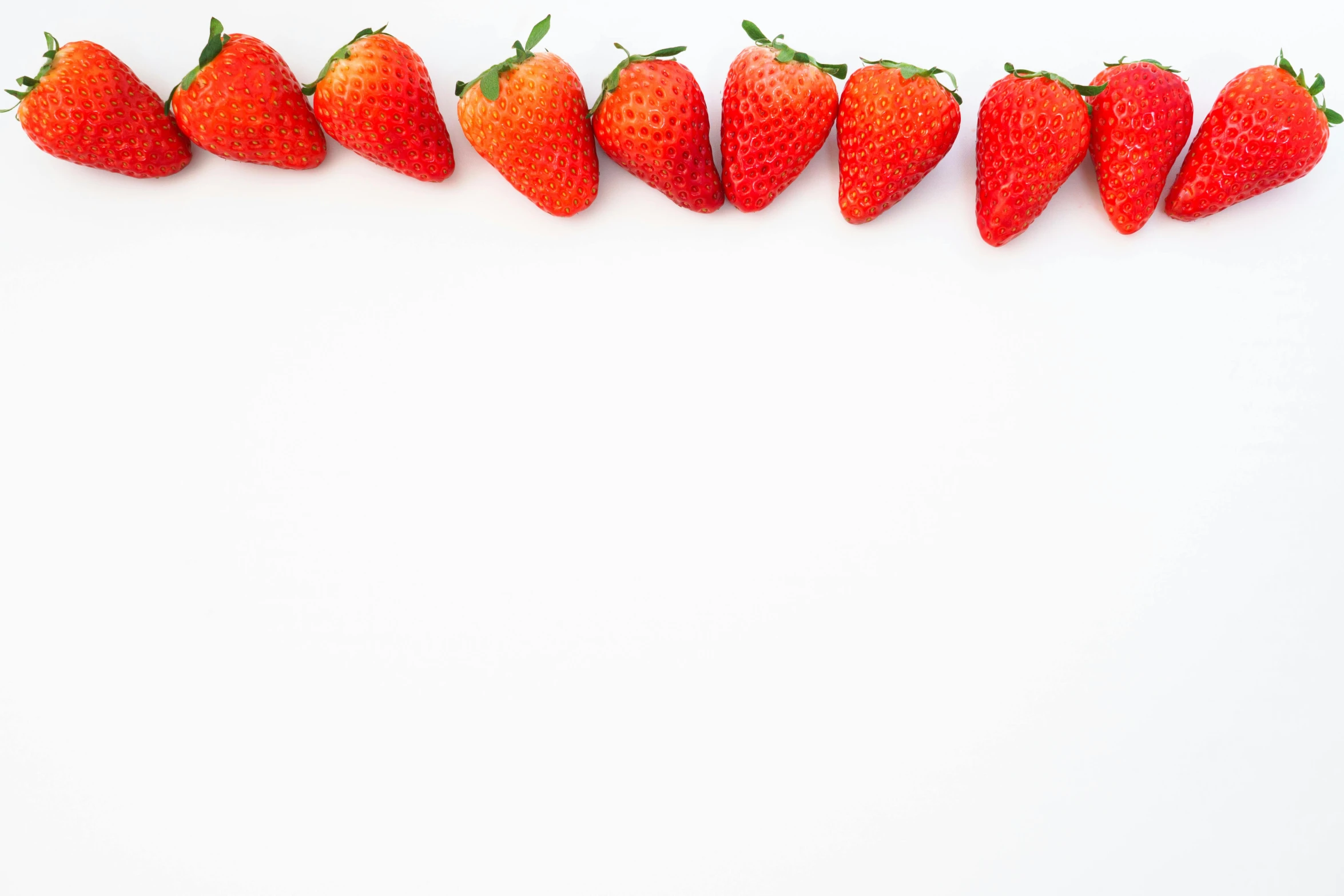 seven whole strawberries lined up in a row