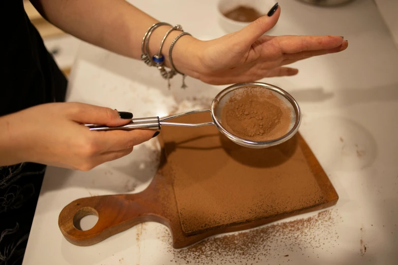 the hands of a person using scissors on a tray of dirt