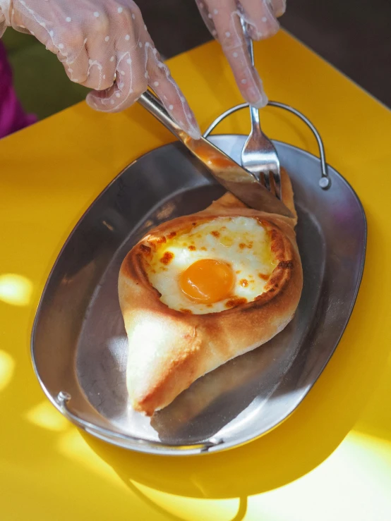 a woman's hands are holding a knife and fork