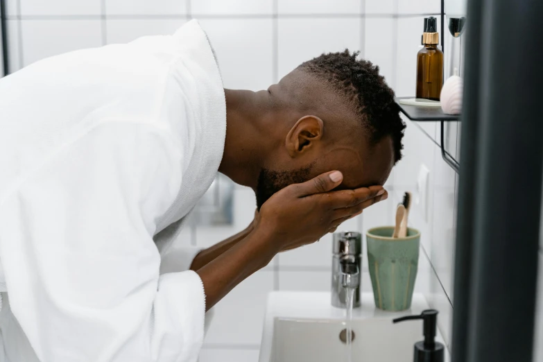 man using dispenser in white bathroom area