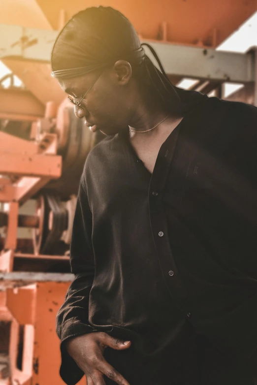 a man wearing a turban standing in front of some metal machinery